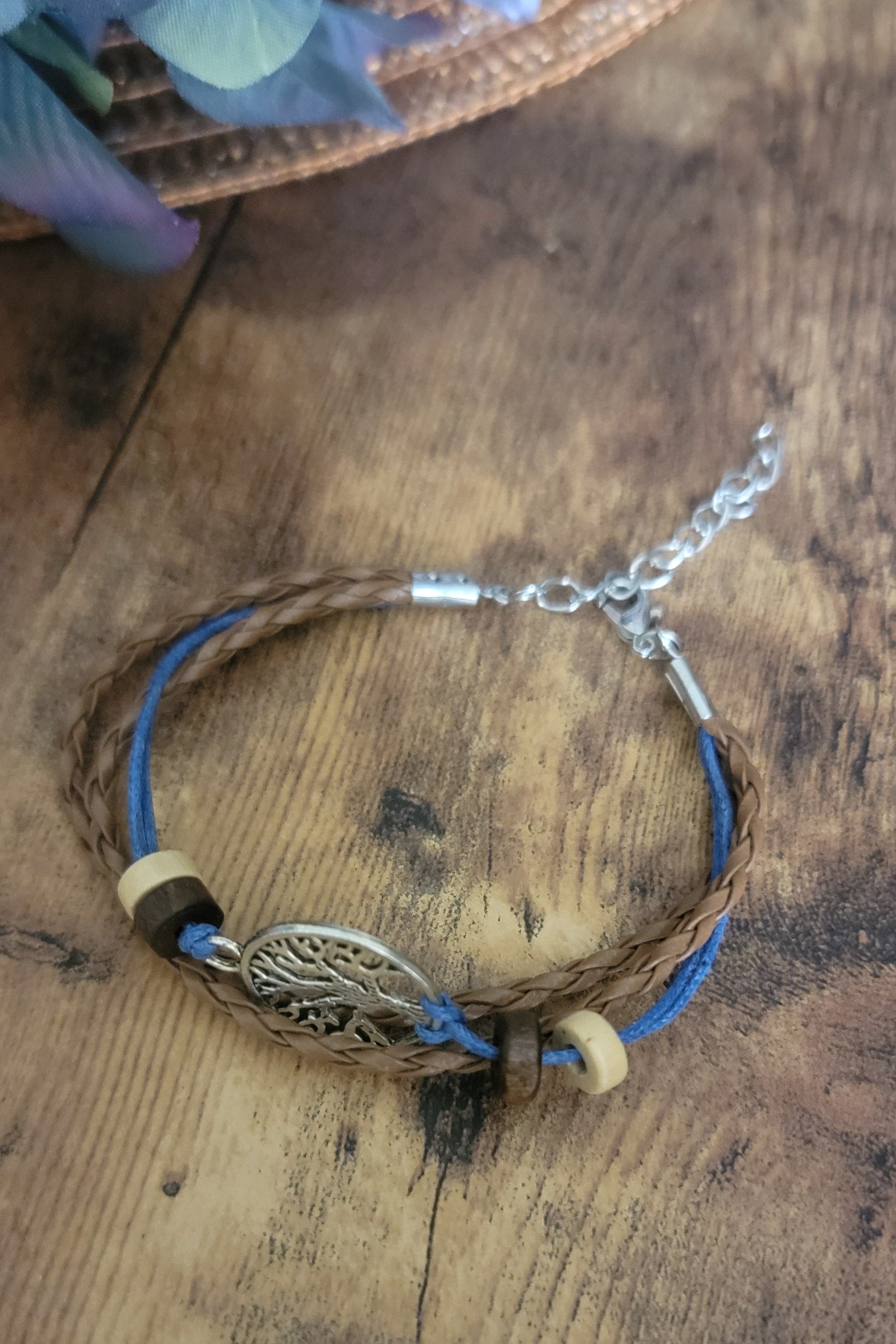 Triple cord adjustabke bracelet , 2 Brown leatherette and one blue cord with beige and Brown beads. At a center, chrome tree of life