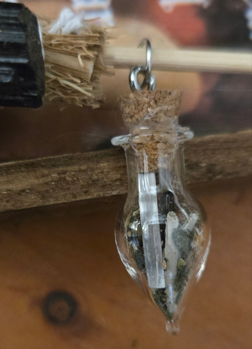 Close-up of protection spell bottle and broom attached to wooden home blessings sign