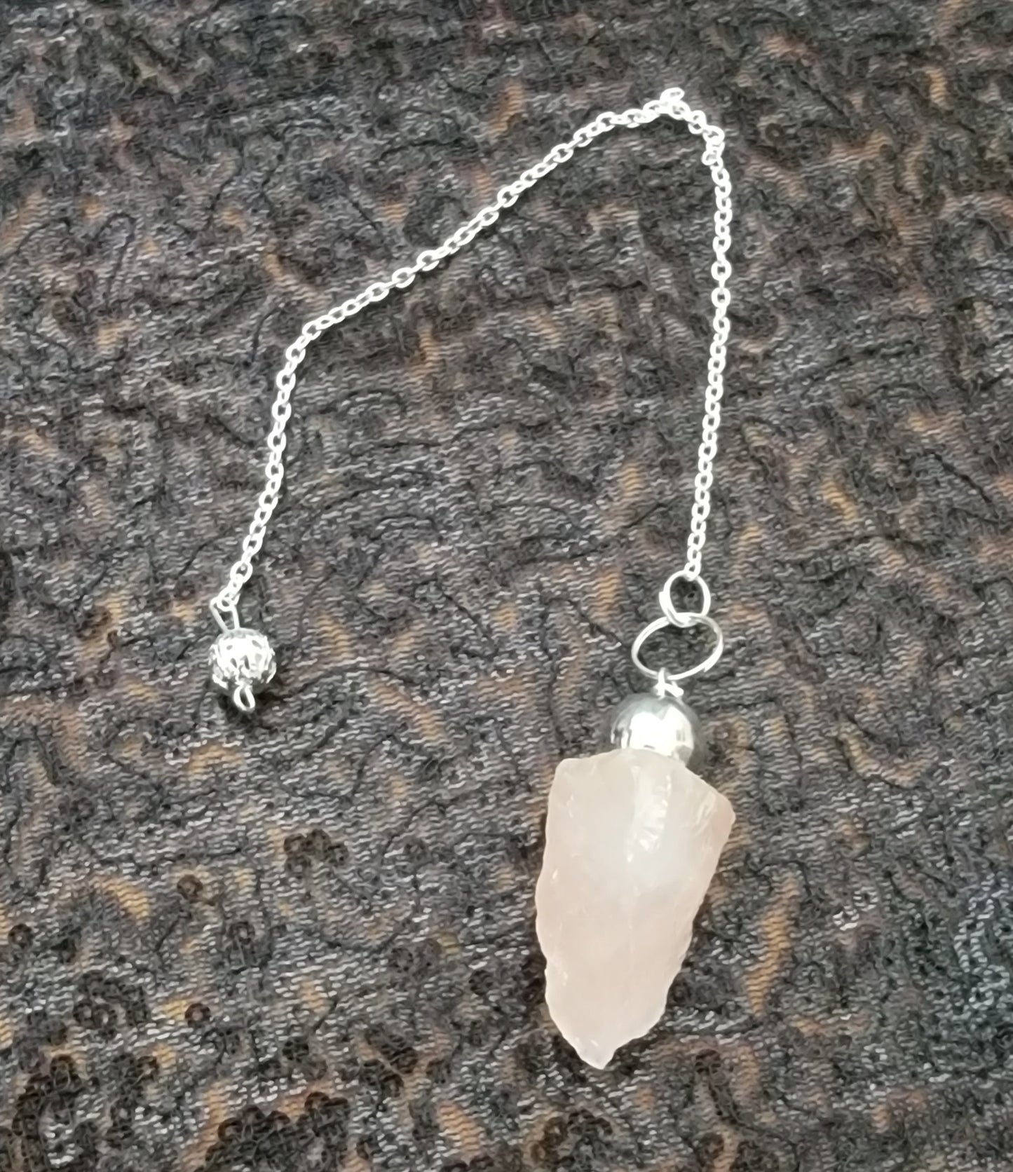 Natural rose quartz, pendulum, hanging on a chrome chain