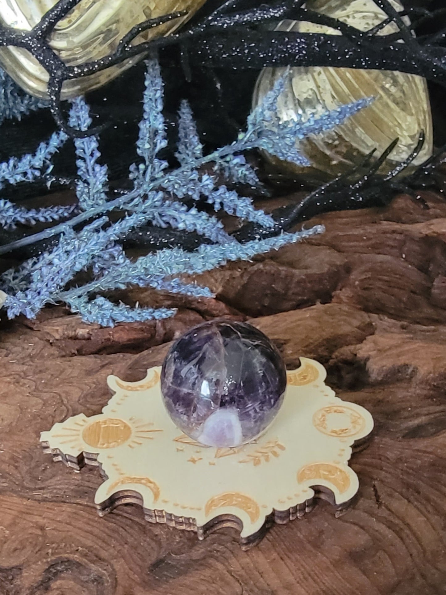 Midnight purple amethyst crystal sphere on a wooden lunar moon phase spearholder