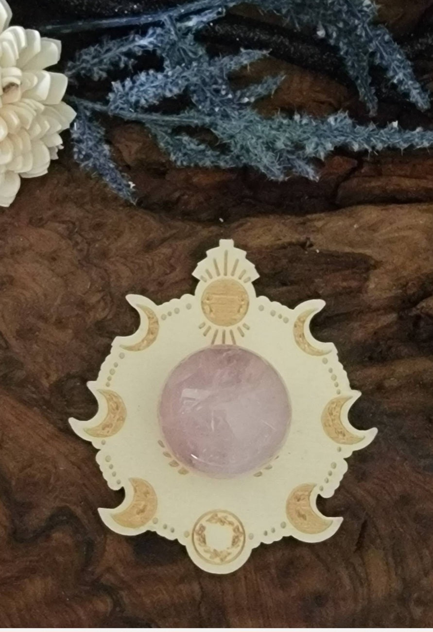 Rose quartz crystal sphere on a wooden lunar phase sphere holder